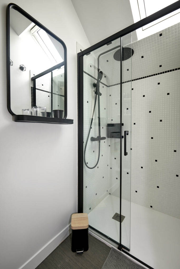 Salle d'eau black and white/noire et blanche avec douche paroi vitrée noire, carrelage mosaïque et robinetterie noire