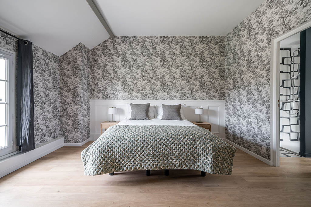 Chambre parentale esprit campagnard avec papier peint motif toile de Jouy gris, soubassement blanc moulures et cimaise