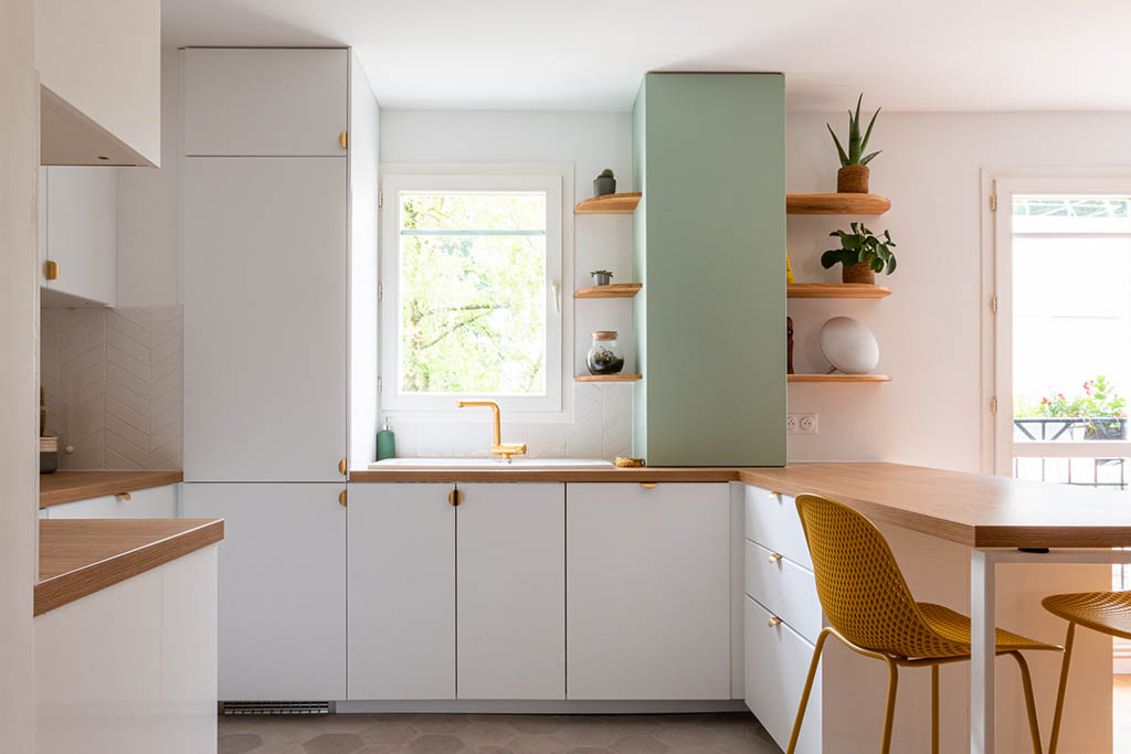 Linéaire cuisine esprit scandinave épuré blanche et verte avec plan de travail bois avec bar déporté, coffrage et étagères bois sur mesure, robinetterie et poignées laiton