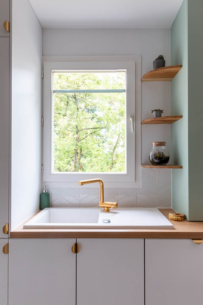 Linéaire cuisine esprit scandinave épuré blanche et verte avec plan de travail bois avec bar déporté, coffrage et étagères bois sur mesure, robinetterie et poignées laiton